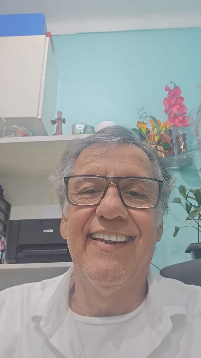 Dr. Marquinho Barreto de jaleco branco, sorrindo em sua sala.