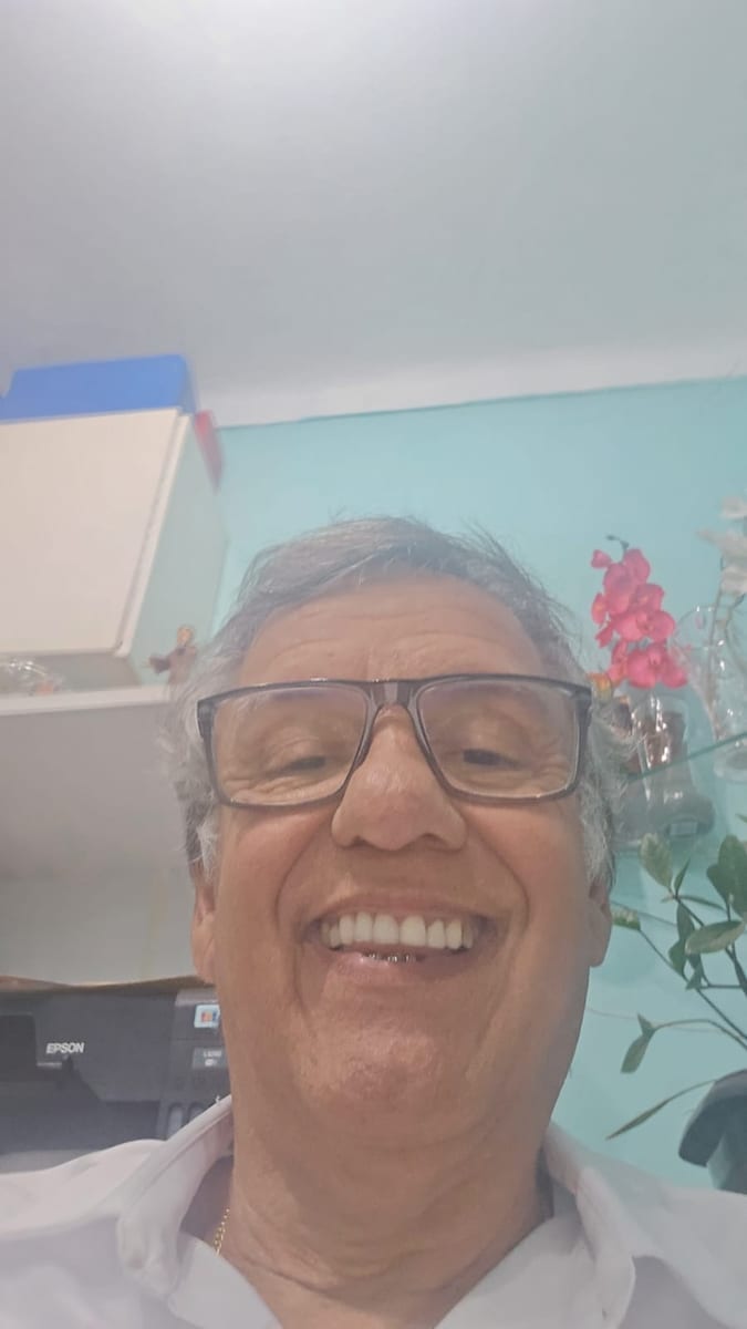 Dr. Marquinho Barreto sorri em sua sala de trabalho, de camisa branca.