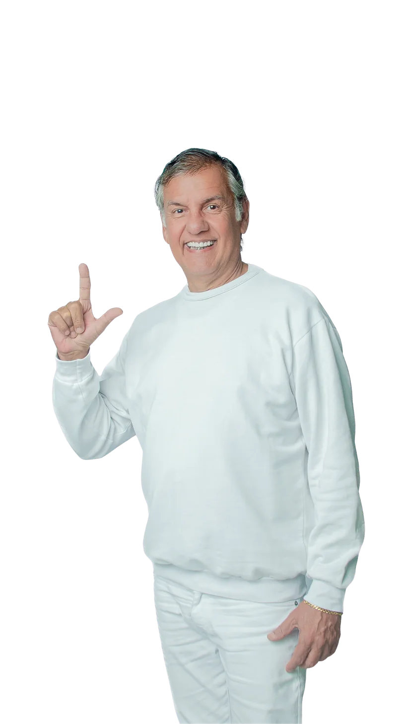 Dr. Marquinho Barreto, de roupa branca, sorrindo com a mão erguida fazendo o gesto da letra L.
