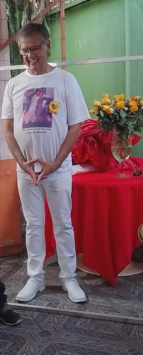 Dr. Marquinho Barreto, de camiseta e calça brancas, sorri em pé durante um encontro com apoiadores.